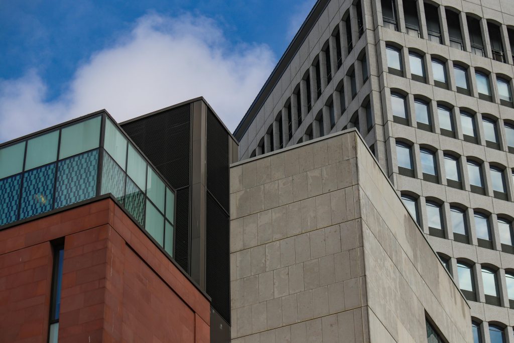 A striking view of modern architecture against a clear blue sky, showcasing geometric forms.